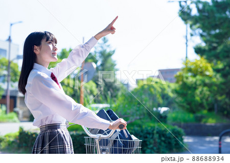空を見上げる指を指す、自転車通学する女子高校生 住宅地 市街地 綺麗な新緑 空を見上げる指を指す、自転車通学する女子高校生 住宅地 市街地 綺麗な新緑 88688934