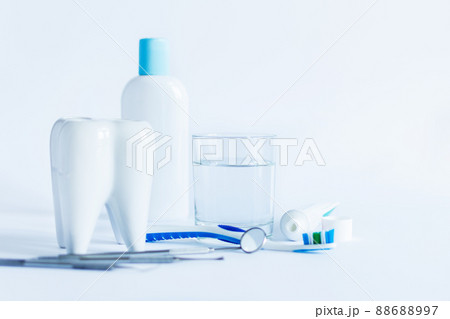 Oral hygiene products and model of tooth on white background. 88688997