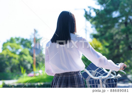 自転車を押して通学する後ろ姿の女子高校生 住宅地 市街地 綺麗な新緑の写真素材 6081