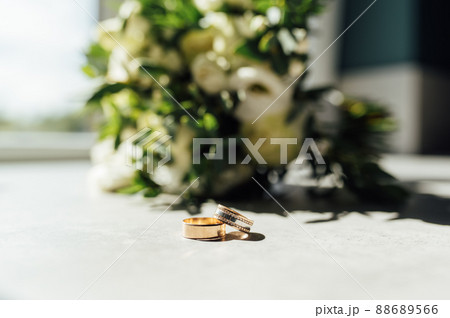 Bridal bouquet and wedding rings on window 88689566