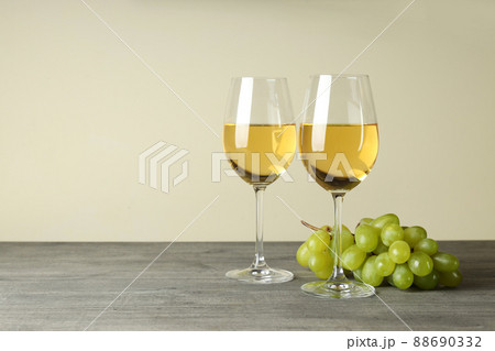 Glasses of white wine and grape on gray textured table 88690332
