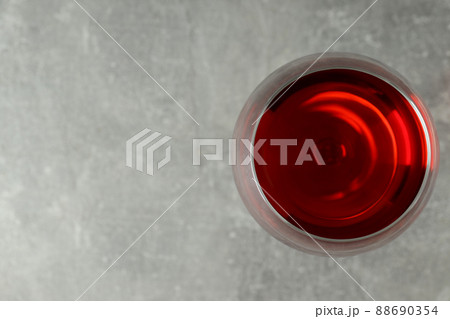 Glass of red wine on gray textured background Glass of red wine on gray textured background 88690354