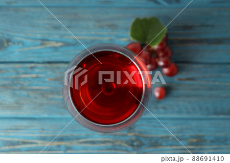 Glass of red wine and grape on wooden table Glass of red wine and grape on wooden table 88691410