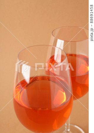 Glasses of wine on beige background, close up Glasses of wine on beige background, close up 88691458