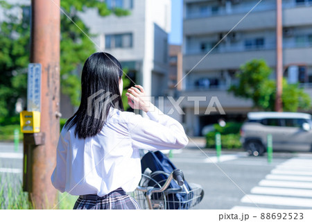 信号待ちする、自転車通学する女子高校生 後ろ姿 住宅地 市街地 綺麗な新緑 信号待ちする、自転車通学する女子高校生 後ろ姿 住宅地 市街地 綺麗な新緑 88692523