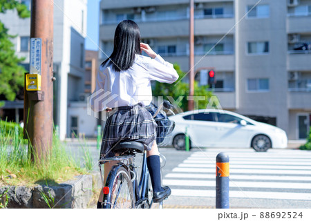 信号待ちする、自転車通学する女子高校生 後ろ姿 住宅地 市街地 綺麗な新緑 信号待ちする、自転車通学する女子高校生 後ろ姿 住宅地 市街地 綺麗な新緑 88692524