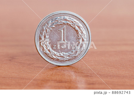 Polish 1 zloty coin on wooden table. Polish 1 zloty coin on wooden table. 88692743