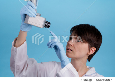 portrait of a young Caucasian female doctor looking at CCTV camera as an idea of monitoring doctors at work portrait of a young Caucasian female doctor looking at CCTV camera as an idea of monitoring doctors at work 88693607