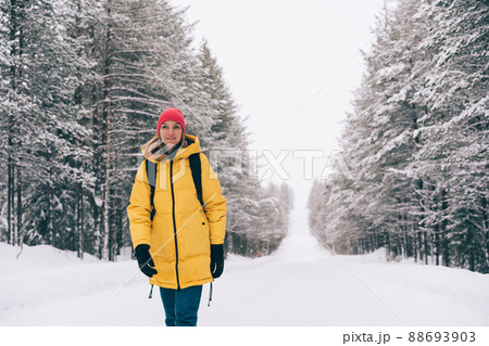 Woman in outerwear walking in winter forest Woman in outerwear walking in winter forest 88693903