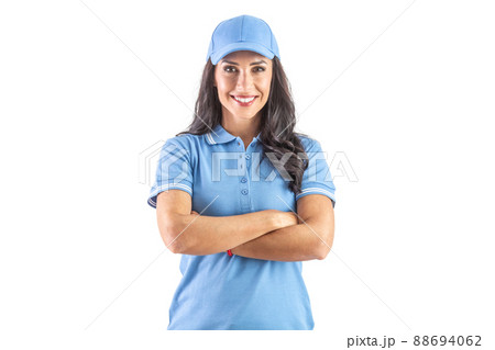 Dark-haired widely smiling woman standing in blue cap and t-shirt with hands crossed over chest. Isolated background Dark-haired widely smiling woman standing in blue cap and t-shirt with hands crossed over chest. Isolated background 88694062