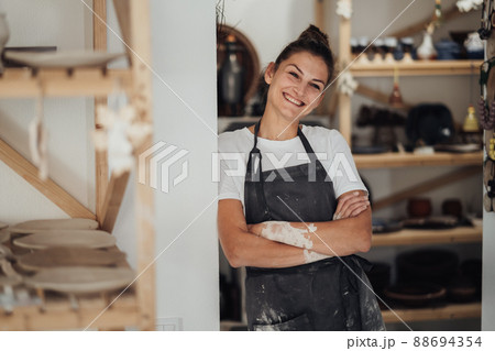 Portrait of Cheerful Potter, Female Entrepreneur in Her Clay Studio, Woman Happy Owner of a Small Pottery Business Portrait of Cheerful Potter, Female Entrepreneur in Her Clay Studio, Woman Happy Owner of a Small Pottery Business 88694354