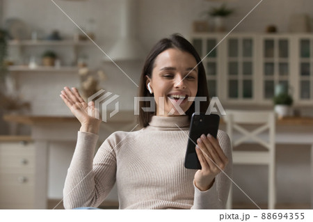 Happy girl with wireless earphone talking on video call, Happy girl with wireless earphone talking on video call, 88694355