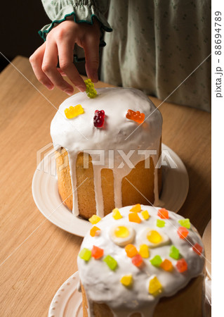 Girl decorates Easter cakes with jelly candies Girl decorates Easter cakes with jelly candies 88694789