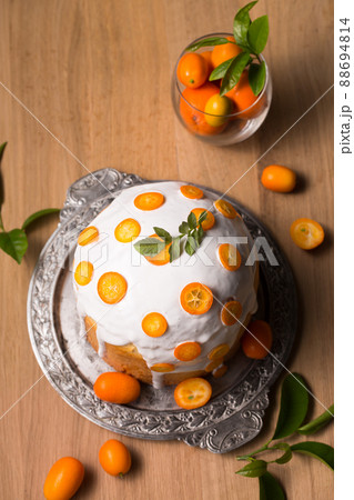 Easter cake and juicy kumquats on a wooden table Easter cake and juicy kumquats on a wooden table 88694814