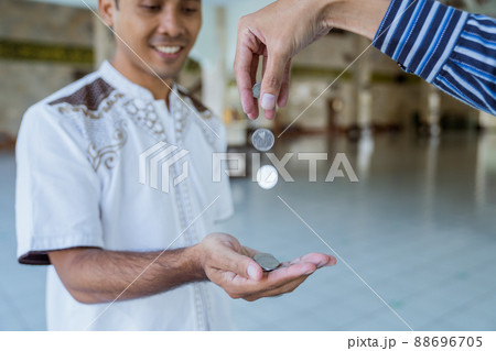 muslim paying some zakat charity using cash at the mosque muslim paying some zakat charity using cash at the mosque 88696705