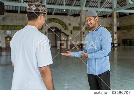 male muslim at the mosque welcoming guest to enter 88696707