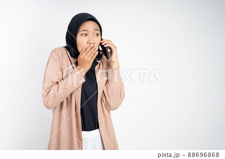 muslim woman in hijab whispering while calling on phone muslim woman in hijab whispering while calling on phone 88696868
