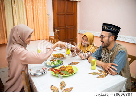 muslim mother serving some food for family dinner muslim mother serving some food for family dinner 88696884