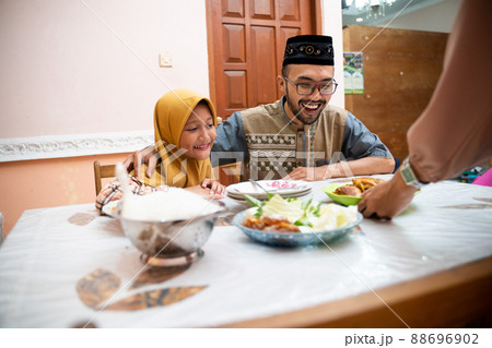 muslim father and daughter during iftar dinner on ramadan kareem muslim father and daughter during iftar dinner on ramadan kareem 88696902