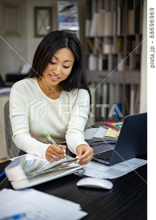 Portrait of beautiful brunette woman interior designer working use laptop creating kitchen project Portrait of beautiful brunette woman interior designer working use laptop creating kitchen project 88696969