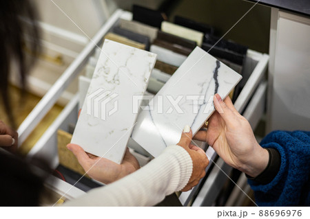 Closeup hands creative female interior designer and customer choosing marble stone color 88696976