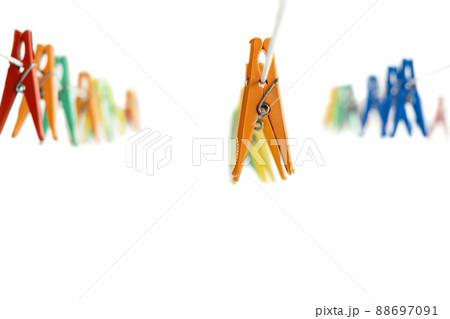 White background with hanging multi-colored clothespins for drying clothes. white background. copy space 88697091