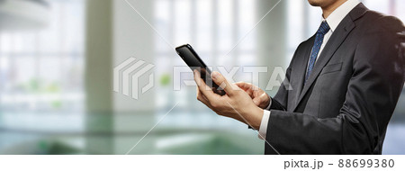 スマートフォンを操作しているビジネスマン スマートフォンを操作しているビジネスマン 88699380