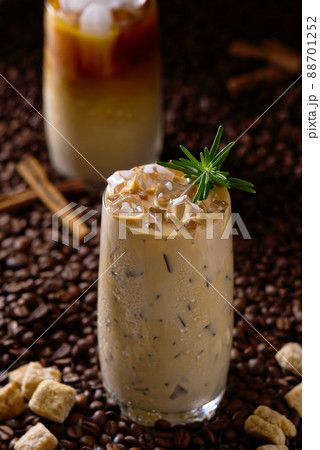 Iced latte coffee. Cup of Iced latte coffee, milk tea on dark coffee seeds background 88701252