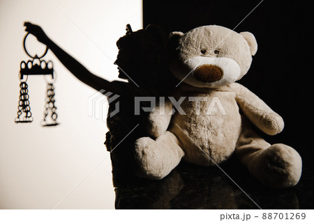 Silhouette of lady of justice on white background and teddy bear 88701269