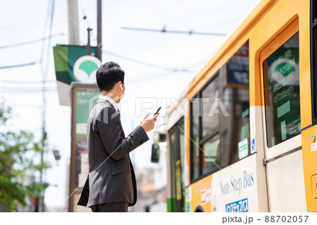 ビジネスマン　イヤホン　バス停　バス 88702057