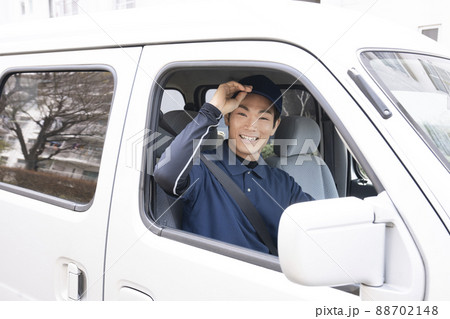 運転席に座って微笑む宅配便の男性 88702148