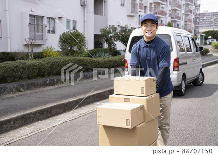 台車で荷物を運ぶ宅配便の男性 台車で荷物を運ぶ宅配便の男性 88702150