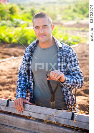 Positive man professional horticulturist with garden shovel at land Positive man professional horticulturist with garden shovel at land 88702674