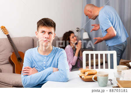 Unhappy teen boy with quarreling parents Unhappy teen boy with quarreling parents 88703181