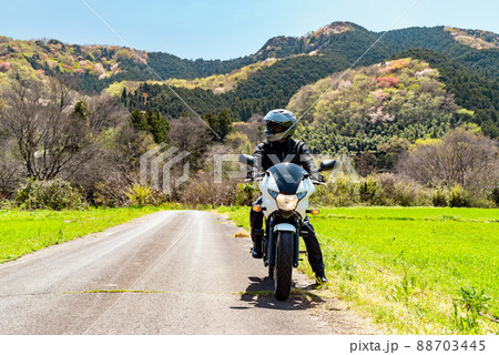 春のバイクツーリングとライダー 若葉と花が萌える里山　b-1 正対 視線右 88703445