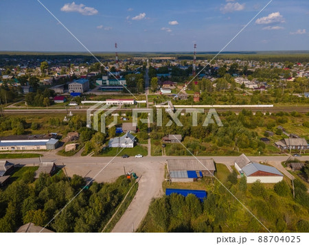 Road between lush trees and houses in autumn 88704025