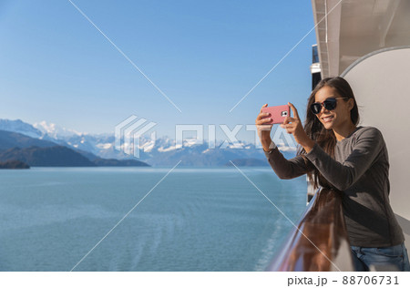 Alaska Glacier bay cruise ship travel tourist looking at icebergs taking pictures using phone in inside passage from balcony deck. Scenic cruising vacation destination panoramic banner 88706731