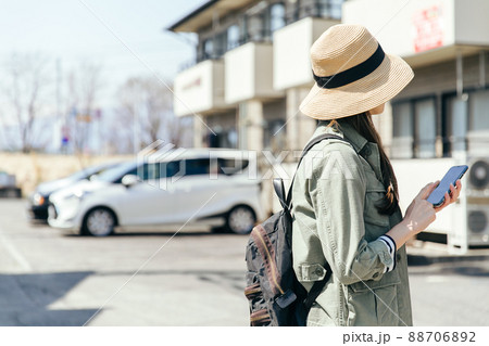 携帯電話を片手に家を探す人　Property search	 88706892