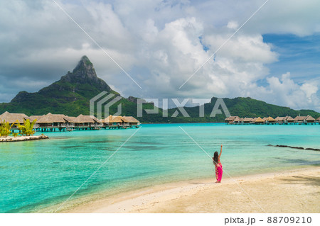 Polynesian hula dancer dancing on Bora Bora beach at luxury overwater bungalows hotel resort at luau show party for tourists. Tahiti, French Polynesia 88709210