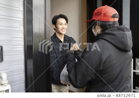 宅配弁当を受け取る男性 88712671