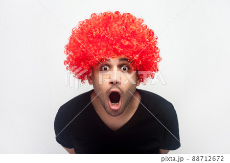 Portrait of overwhelmed shocked man with bristle and red wig staring in surprise at camera, screaming in amazement and delight, disbelief reaction. indoor studio shot isolated on white background Portrait of overwhelmed shocked man with bristle and red wig staring in surprise at camera, screaming in amazement and delight, disbelief reaction. indoor studio shot isolated on white background 88712672