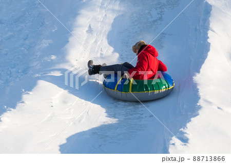Girl riding on snow tube, during tubing in winter park. Winter season, selective focus 88713866