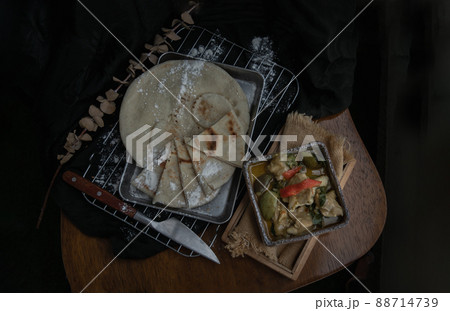 Homemade pita bread served with Green curry chicken (Kaeng khiao wan). 88714739
