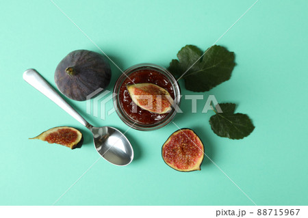 Jar with fig jam, ingredients and spoon on mint background Jar with fig jam, ingredients and spoon on mint background 88715967
