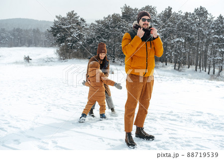Happy family having a walk in winter outdoors in snow Happy family having a walk in winter outdoors in snow 88719539