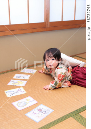 1歳の誕生日に袴を着て一升餅を背負って選び取りをする子供 88722748