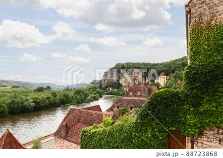 High rocky banks of full-flowing Dordogne river covered with dense forest High rocky banks of full-flowing Dordogne river covered with dense forest 88723868
