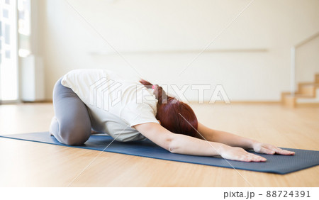 pregnant woman is engaged in yoga. Children asana with knees apart or Balasana pregnant woman is engaged in yoga. Children asana with knees apart or Balasana 88724391