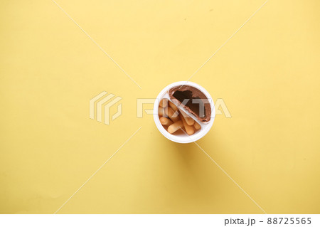 breadstick with chocolate spread cream in a container on yellow background breadstick with chocolate spread cream in a container on yellow background 88725565