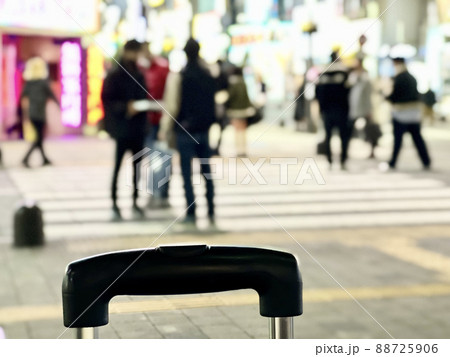 夜の歌舞伎町を歩く人々とキャリーバッグの取っ手のボカシイメージ_冬 夜の歌舞伎町を歩く人々とキャリーバッグの取っ手のボカシイメージ_冬 88725906
